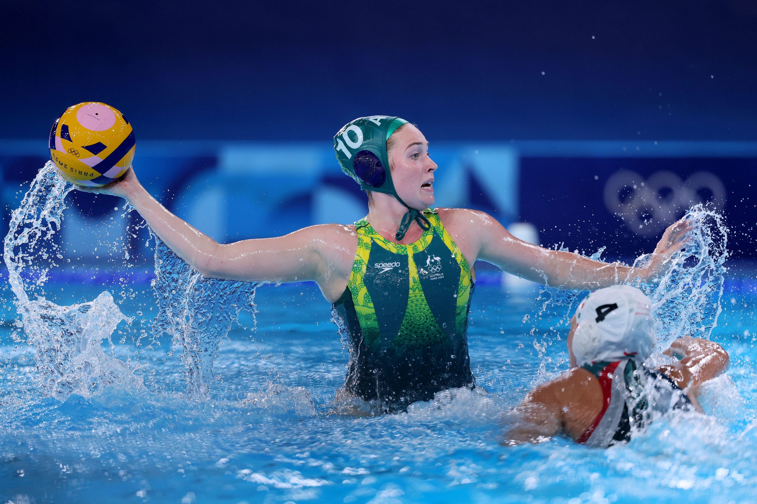 PARIS, FRANCE - AUGUST 04: Alice Williams of Team Australia makes a pass whilst under pressure from Greta Kurucz-Gurisatti of Team Hungary in the Women's Preliminary Round - Group A match between Team Hungary and Team Australia on day nine of the Olympic Games Paris 2024 at Aquatics Centre on August 04, 2024 in Paris, France. (Photo by Clive Rose/Getty Images)